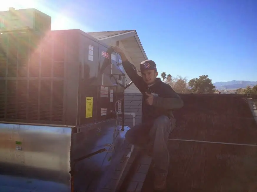 HVAC technician performing Heat Pump Repair on a rooftop unit in Paramus